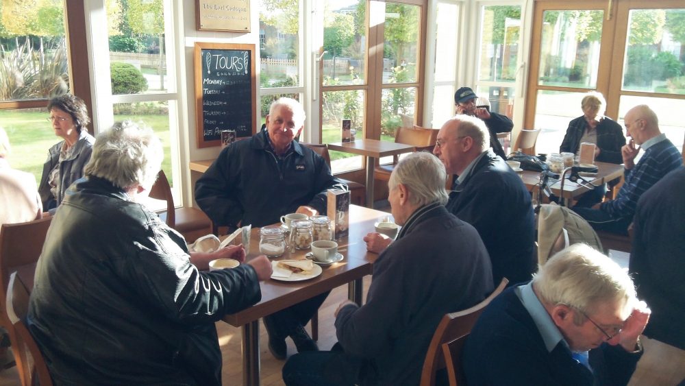 Don Tomlin (looking at the camera) with various members of The Geezers on several tables in the cafeteria of The Royal Hospital Chelsea