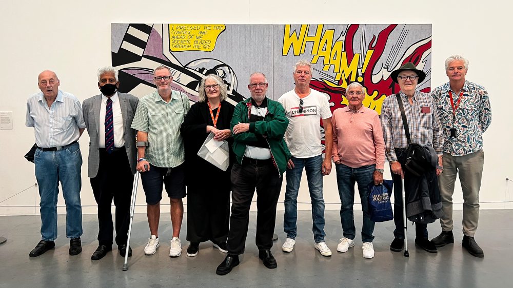 The Geezers and tour guide Wendy Kenny in front of a Roy Lichtenstein's Whaam! It was purchased by the Tate in 1966.