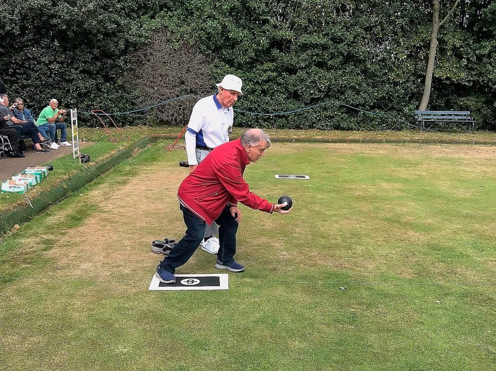 Blind player, Eric Gallagher, with Jim Murray holding the bowl. Jim is visually impaired. At Victoria Park Bowling Club London