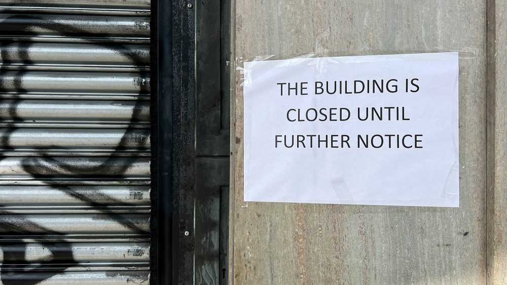 Building closed notice beside what looks like the entrance to the flats on Bow Road, following the fire on the roof.
