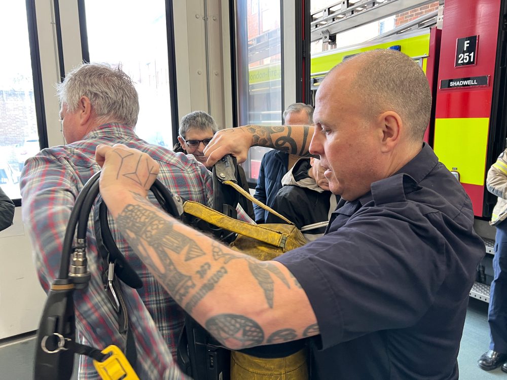 Scott putting a 15kg air cylinder on Eddie's back