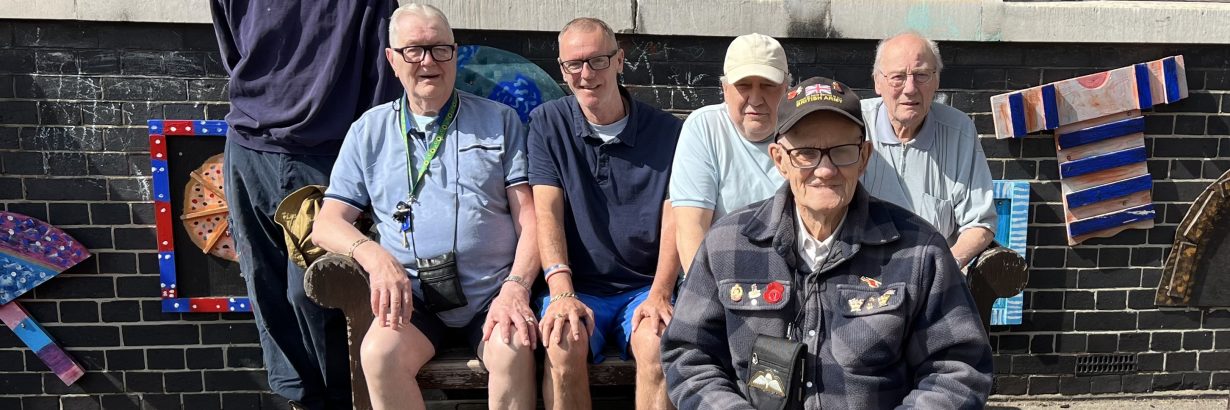 Geezers pose with bench in sunshine