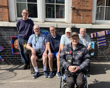 Geezers pose with bench in sunshine