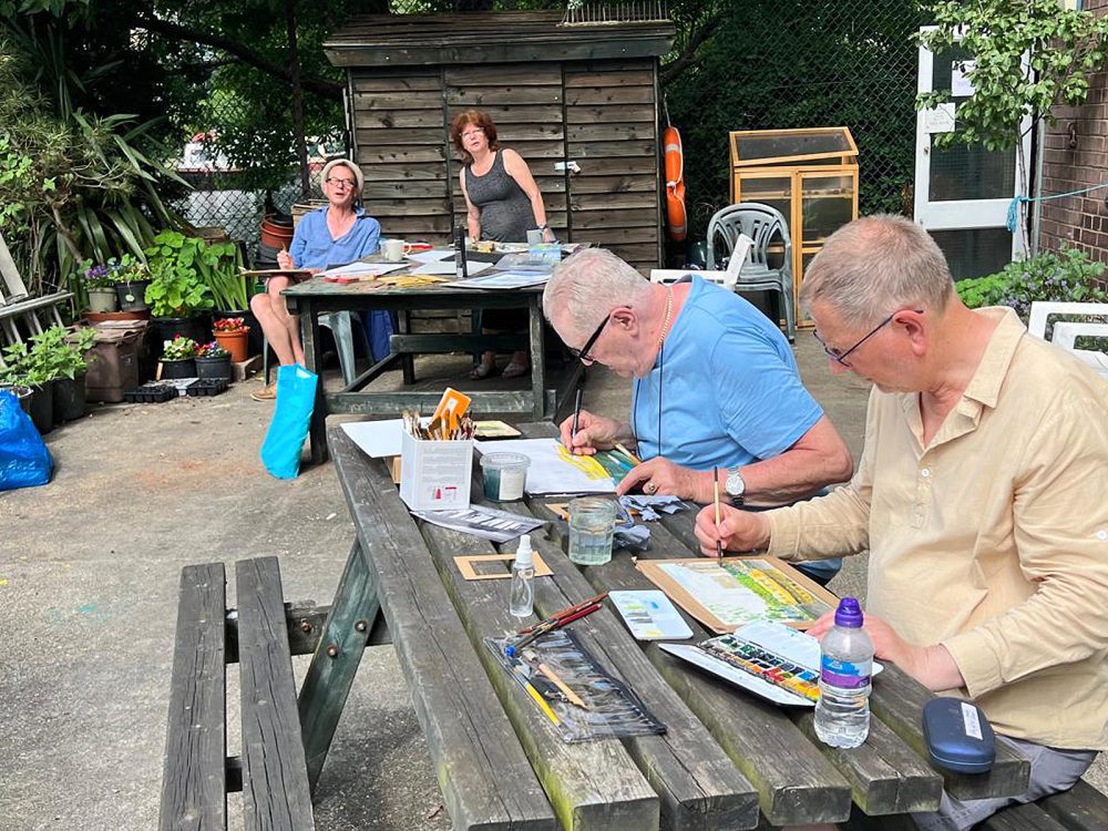Joy Girvin assisting the Geezers in mastering watercolour painting