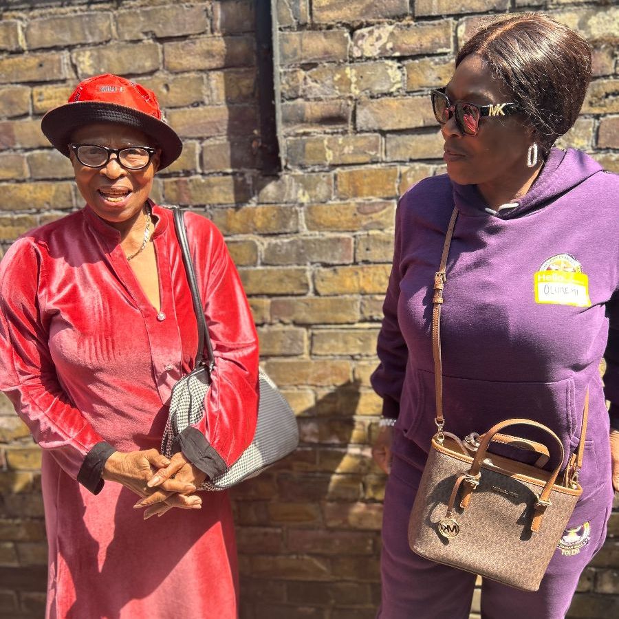 Two women standing in sunshine